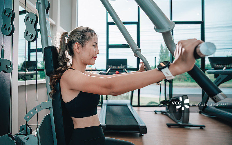 健壮的健身女性锻炼肌肉，做背部下拉练习图片素材