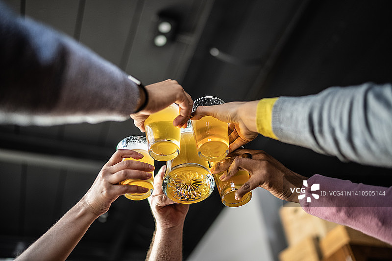 朋友们在酒吧举杯喝啤酒图片素材
