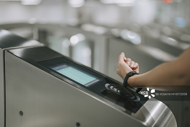 在地铁站入口用智能手表支付的华人女性图片素材