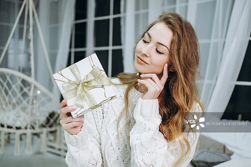 年轻女人在手中观赏礼品盒图片素材