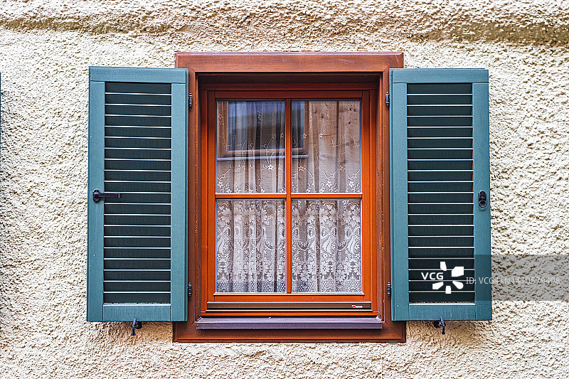 带有蓝色百叶窗和棕色框架的木制窗户图片素材