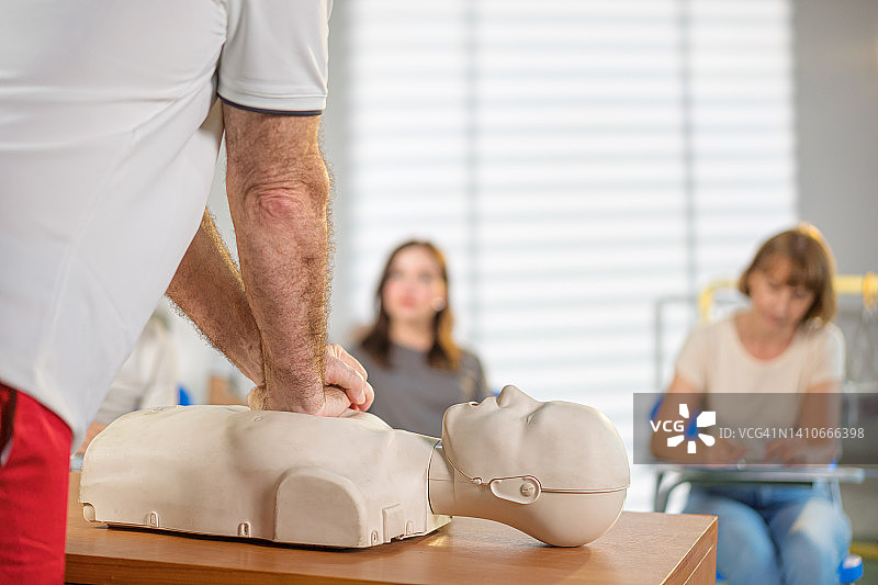 指导员在心肺复苏模拟人上演示胸部按压图片素材