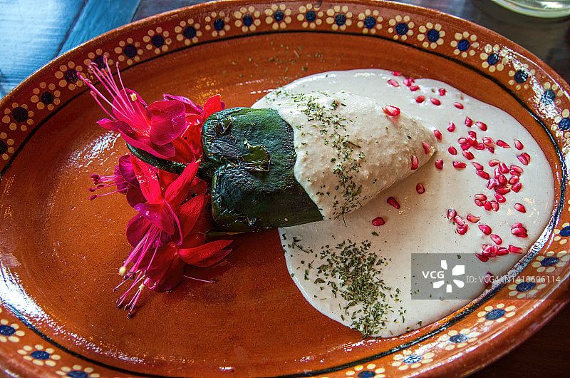 诺加达辣椒，盛在传统的陶土盘中，饰以倒挂金钟花图片素材