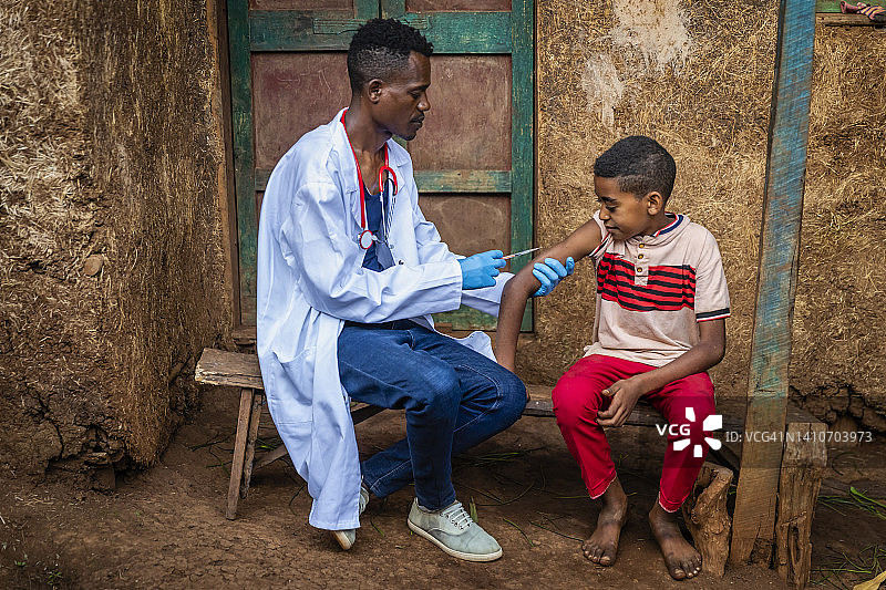 医生在东非小村庄为非洲男孩注射图片素材