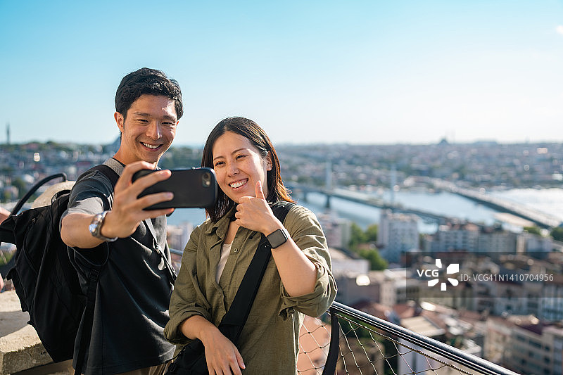 年轻情侣在历史塔顶自拍留念图片素材