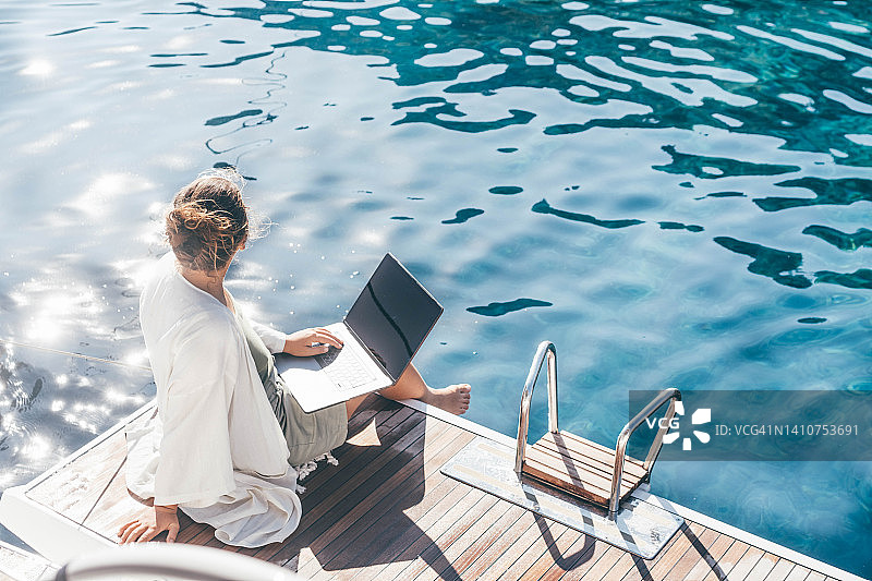 在豪华游艇上度假工作的女人图片素材