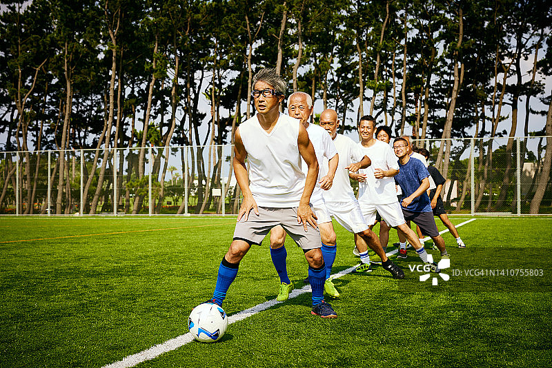 中年男人踢足球图片素材