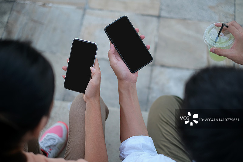 两位朋友用智能手机付款图片素材