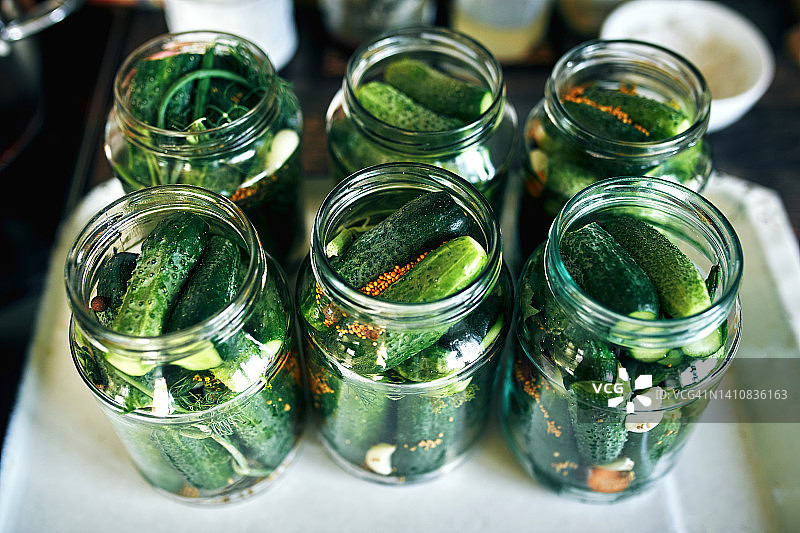 装有嫩黄瓜和盐水的玻璃罐：冬季美食的准备图片素材
