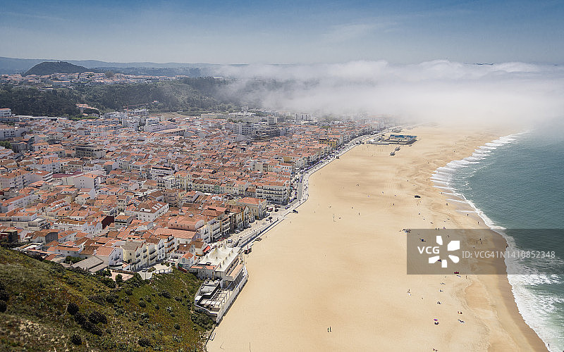 葡萄牙纳扎雷海滨小镇及其海滩在晨雾中，锡蒂奥海角悬崖顶遗址全景图片素材
