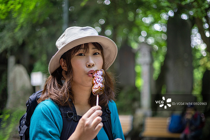 在山上吃团子丸子的女徒步旅行者图片素材