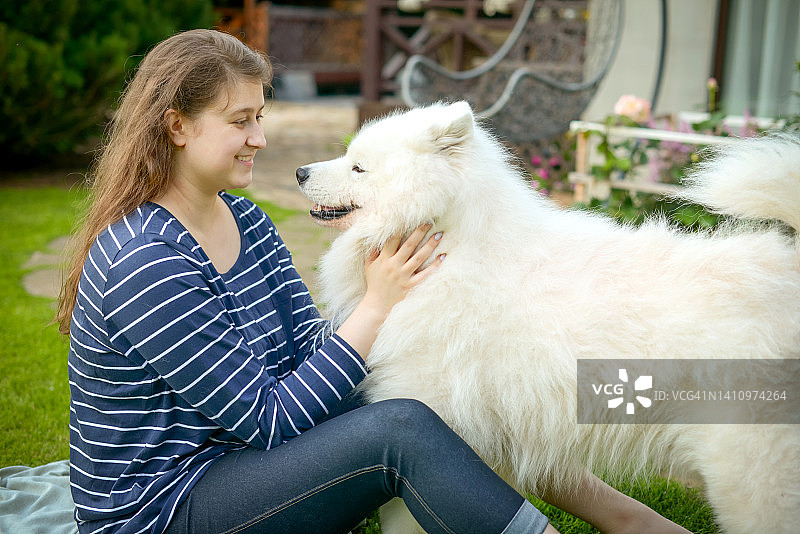年轻女子和萨摩耶犬在户外图片素材