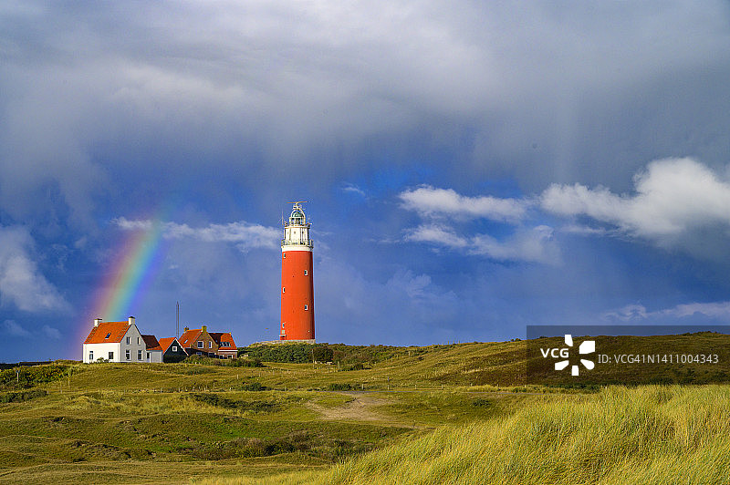 暴风雨秋夜，沙丘中的泰克塞尔岛灯塔与彩虹图片素材