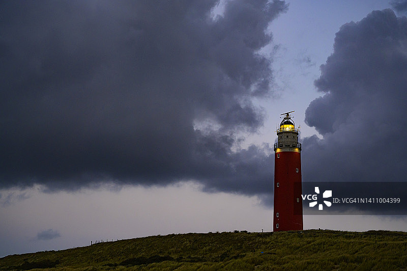 平静秋日下午沙丘中的泰克塞尔灯塔图片素材