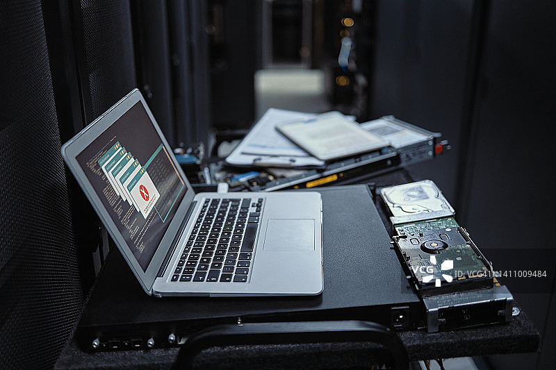 由于系统崩溃或故障，笔记本电脑上出现软件错误警告，数据库监控硬件显示警报符号或服务器存储室内因错误导致防火墙被破坏图片素材