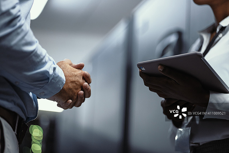 IT技术人员在服务器机房使用数字平板电脑，程序员修复系统和网络，工程师合作修复安全软件图片素材