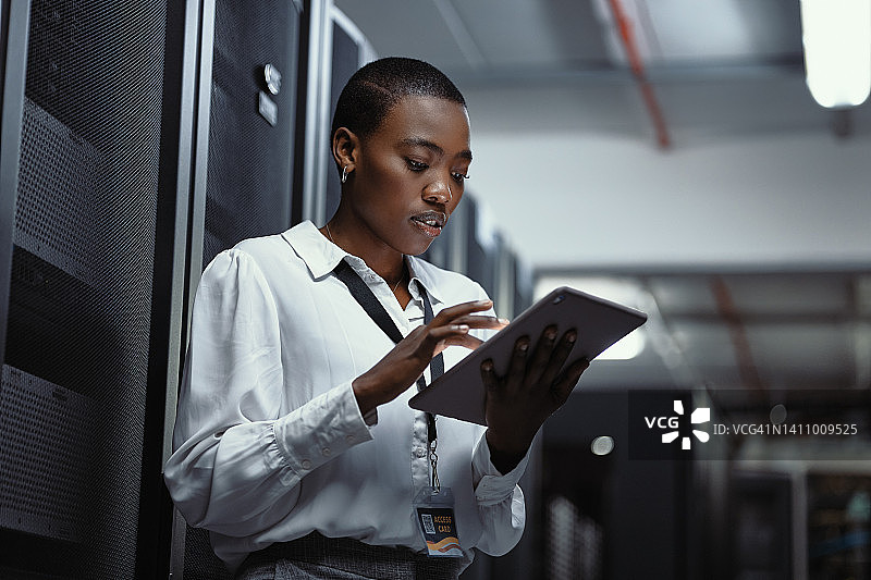 IT技术员在服务器机房使用平板电脑。女程序员在数据中心维护时修复计算机系统和网络。工程师更新机器上的安全软件图片素材