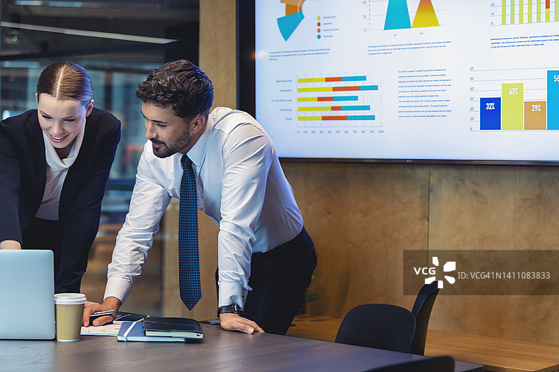 在现代办公室使用笔记本电脑工作的商人们图片素材