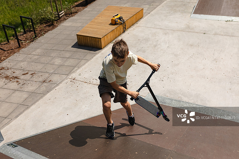 玩特技滑板车的男孩图片素材