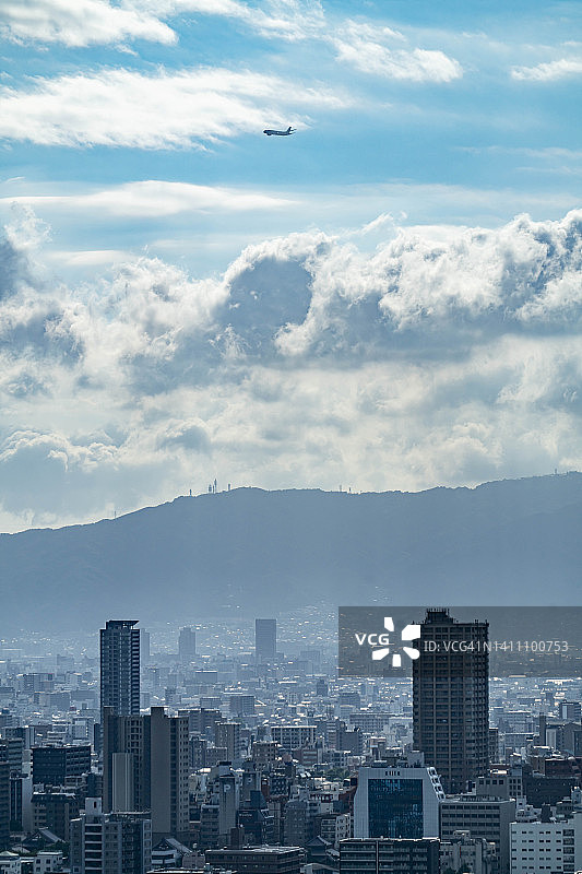 在日本大阪市上空飞行的飞机图片素材