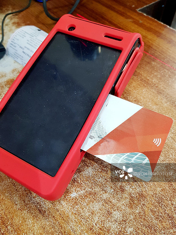 商店柜台上插入信用卡的便携式零售收费机图片素材