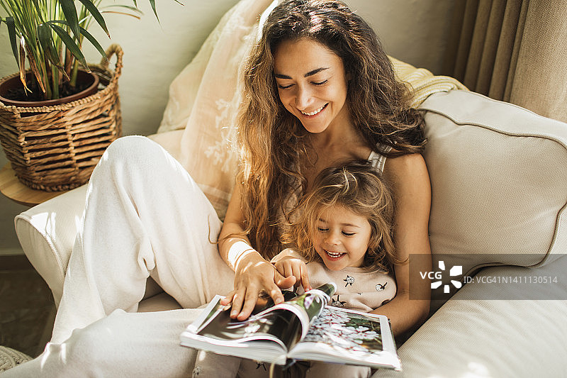 母女拥抱欢笑，一同看相册图片素材