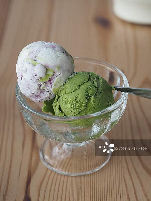 木桌上玻璃杯中的抹茶冰淇淋和混合水果图片素材