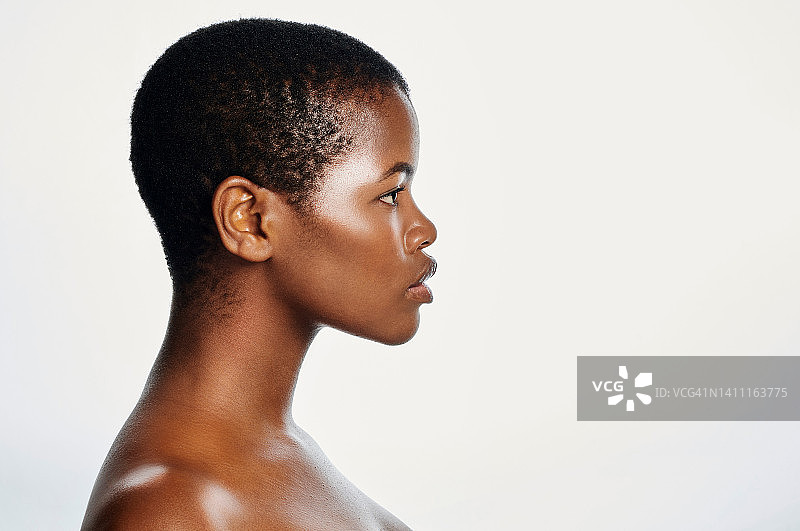 封面模特象征着自豪的黑人美丽，完美的黑色素肤色和肤色。美丽、自信、前卫的女性的脸部和头像，皮肤健康，在工作室里剪着平头图片素材