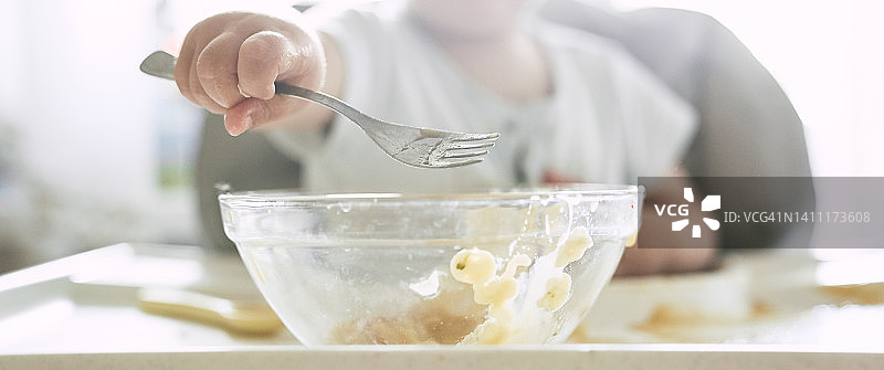 可爱宝宝用叉子吃面条图片素材