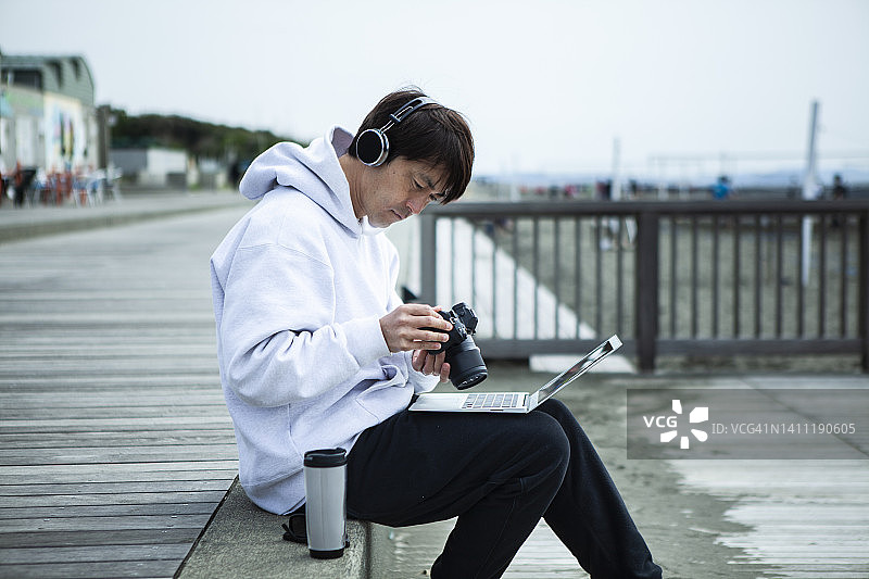 在海滩工作的视频创作者图片素材