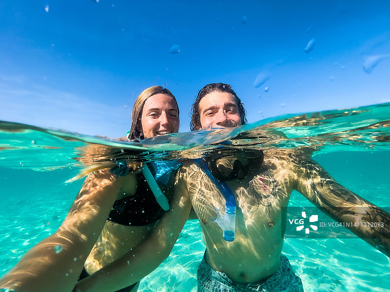 情侣在马尔代夫清澈的海水中自拍图片素材