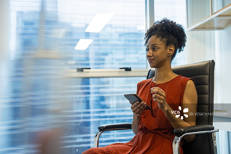 非洲裔美国妇女用手机交易的半身肖像照图片素材