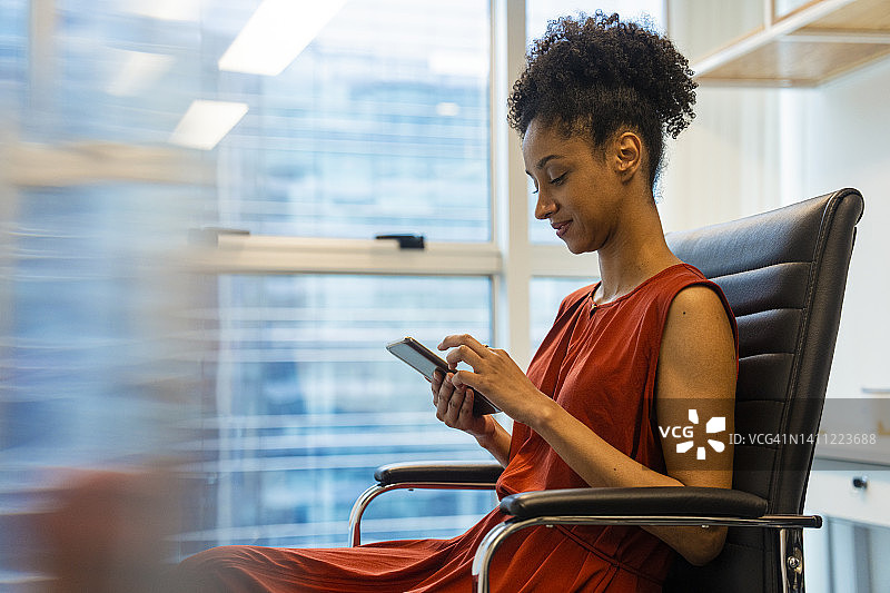 非裔美国中年女商人用手机洽谈商务的侧面像图片素材