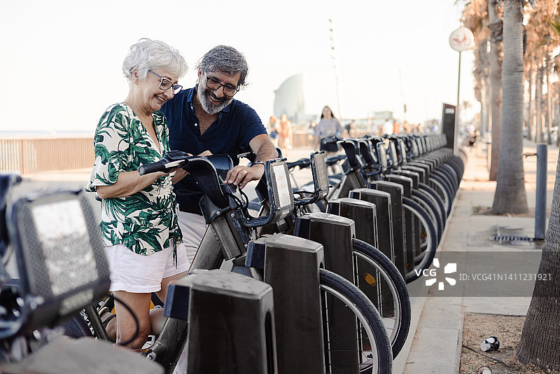 老年夫妇度假租赁电动自行车探索城市人像图片素材