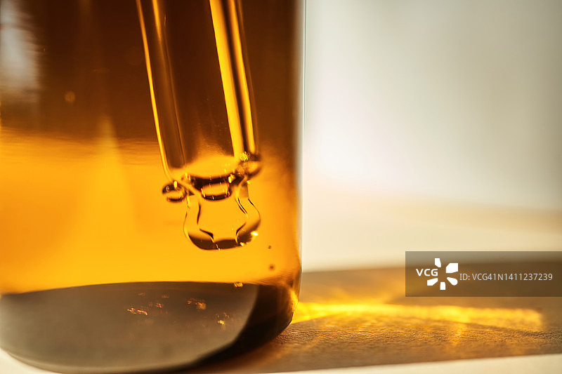 阳光下的精华液瓶与滴管特写图片素材