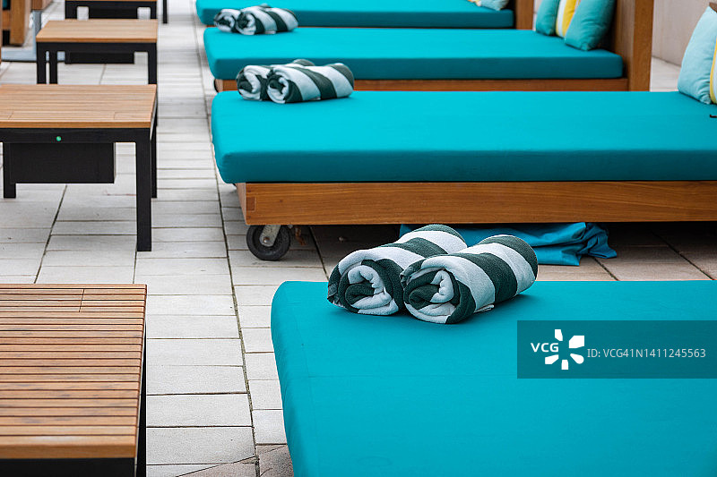 泳池边日光躺椅上的毛巾图片素材