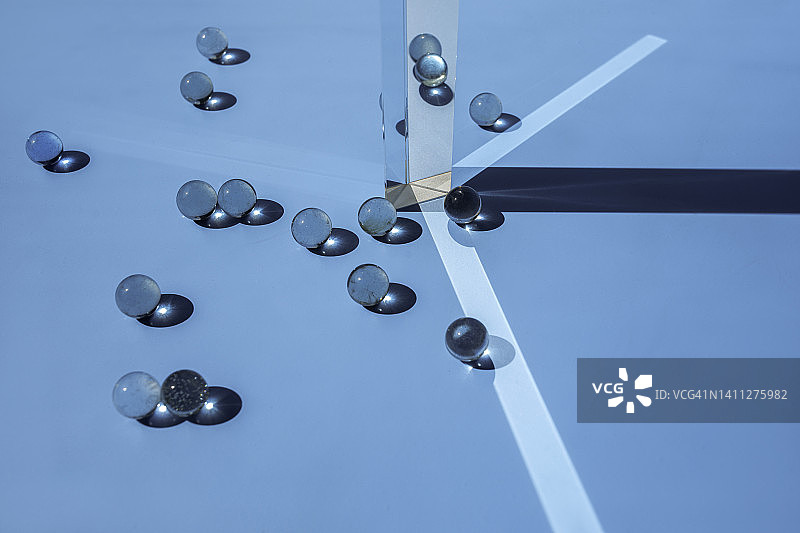 蓝色背景上的玻璃棱镜和玻璃球图片素材