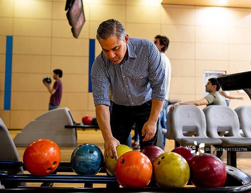 男人打保龄球时捡球图片素材