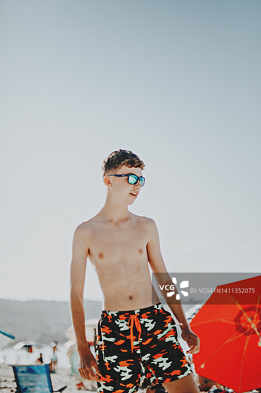 年轻男子戴太阳镜在海滩上的肖像图片素材