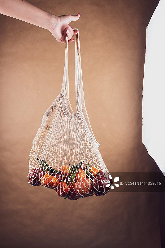 工作室幕后：摄影或视频制作，网兜装着苹果和橘子在背景前，右侧有灯箱图片素材