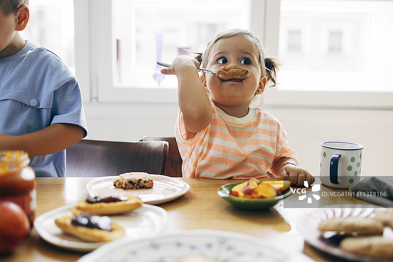 用勺子吃果酱的小女孩图片素材