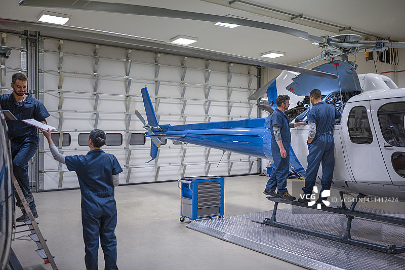 一群机械师站在直升机旁图片素材
