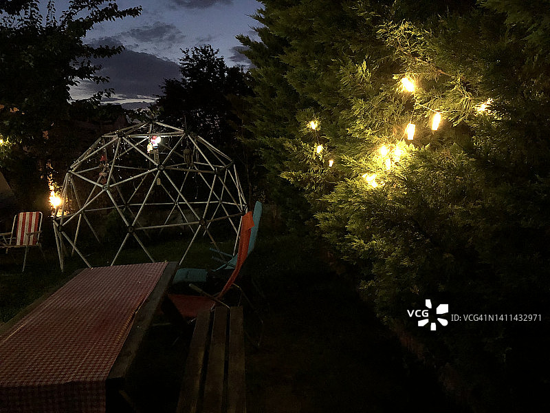 夏日夜晚的网格穹顶，木桌与沙滩椅图片素材