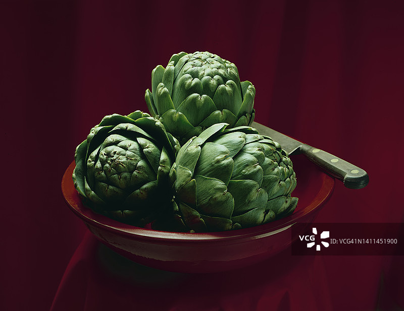 红色碗里的朝鲜蓟图片素材