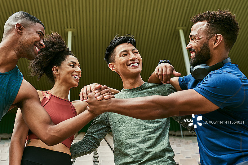 不同肤色的运动员朋友在锻炼或比赛前握手打赌或互相挑战，运动团队互相鼓励图片素材