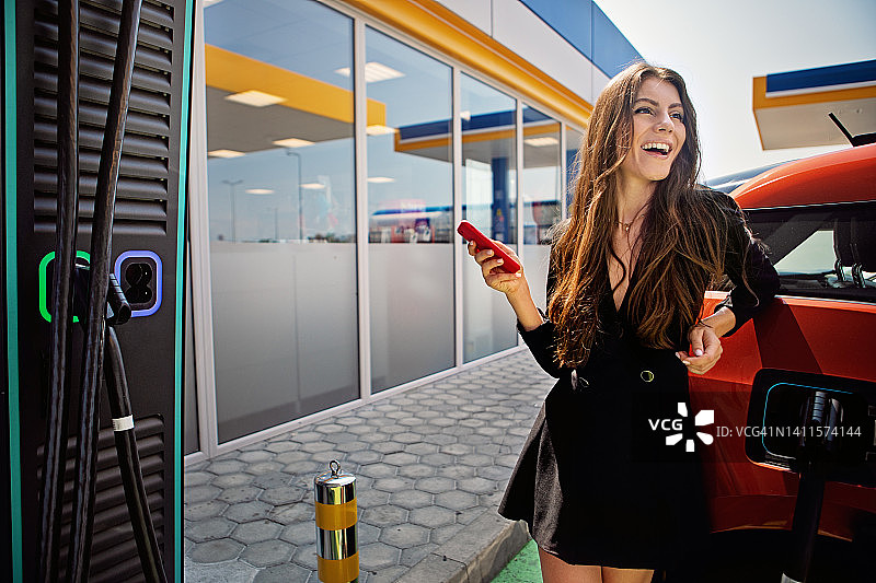 为电动汽车充电的年轻女子肖像图片素材
