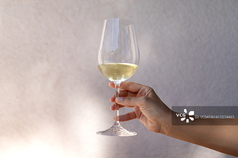 女子手持一杯白葡萄酒图片素材