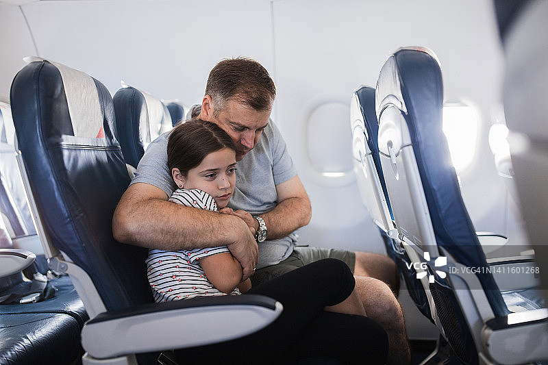 男人拥抱因害怕坐飞机的女儿图片素材