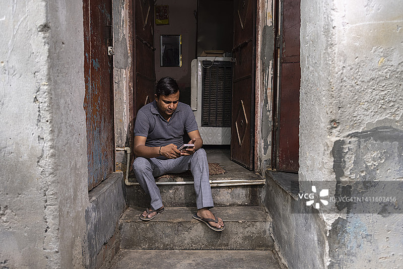 中年男人坐在台阶上使用手机图片素材