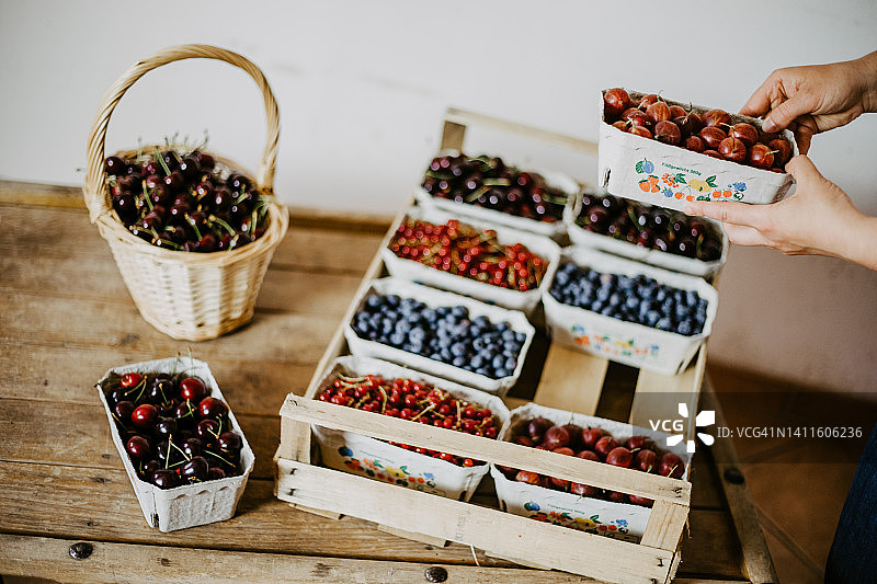 农民在当地农贸店将新鲜草莓放入木箱图片素材